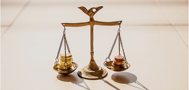 Geldstücke auf einer alten Waage verteilt