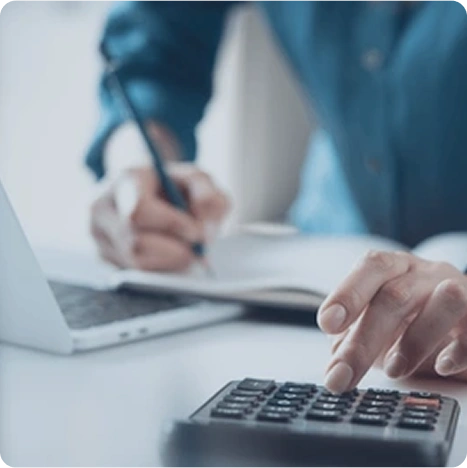Mann, der mit Taschenrechner, Stift und Laptop arbeitet