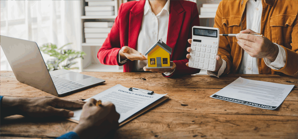 Ehepaar mit Modell eines Hauses und Taschenrechner in einem Büro